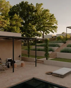 Modern residential outdoor space featuring concrete, gravel, stone, and metal elements.