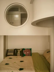 A modern children's bedroom with a green and yellow bedspread and animal-themed pillows.