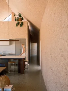 A sleek, modern kitchen with a minimalist design, featuring a combination of OSB board and concrete materials, with an emphas