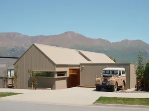 Modern house with a corrugated metal exterior and a Land Rover parked in front.