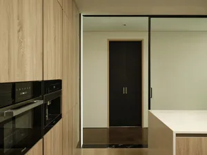 Modern residential kitchen featuring wooden cabinets and sleek, minimalist design elements.