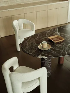 Modern dining room with marble table and white upholstered chairs.
