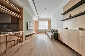A modern living room with wooden furniture, including a white sofa with green cushions, a built-in entertainment center, and 