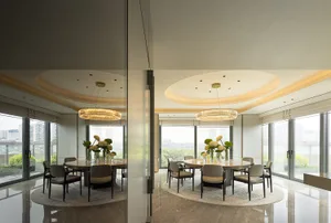 A modern dining room featuring glass and marble materials.