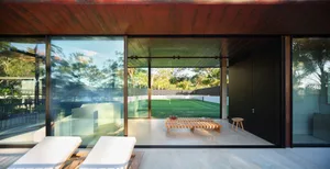 Modern, minimalist patio with concrete, glass, and wood elements.
