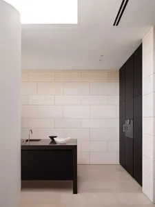 A minimalist modern kitchen with marble countertops and backsplash.