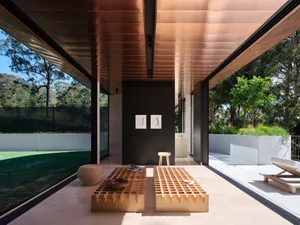 A minimalist living room with natural wood elements, a grid coffee table, and a wall art piece.