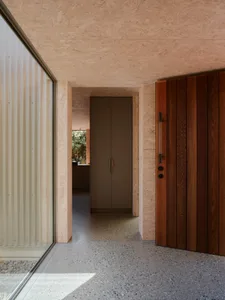 A modern entrance with wooden materials and OSB walls.