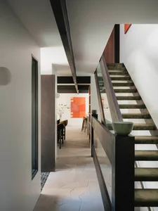Modern interior design featuring a wooden staircase with a glass rail.
