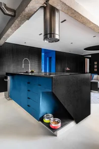 Modern residential kitchen featuring a blue metal island counter with black countertops and sleek, minimalist design.