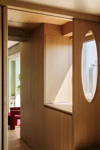Modern, wooden cabinetry with an oval window and a view of the city.