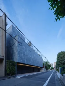 A modern building exterior made of dark grey, textured concrete.