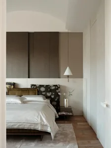 Modern minimalist bedroom featuring a wooden headboard and fabric accents