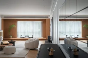 A modern living room featuring wooden coffee tables, glass vases, and contemporary furniture with soft upholstery.