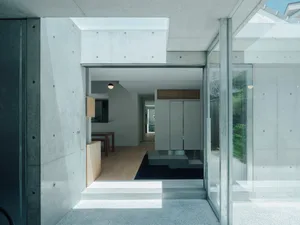 A minimalist interior design featuring concrete walls and floor.