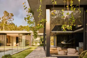 Modern residential interior with concrete and glass elements, featuring tranquil outdoor space.