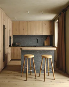 Modern kitchen with stone countertop and wooden stools.