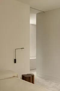 Photograph of a modern bedroom with neutral-toned walls and minimalist decor.
