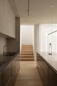 Modern residential kitchen with concrete and stainless steel finishes.
