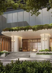 Modern hotel entrance featuring a green living wall, concrete steps, and large glass doors.
