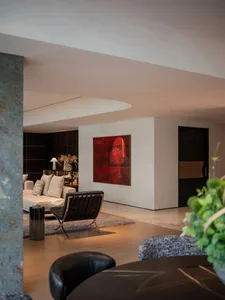 Modern living room featuring minimalist furniture and a bold red abstract painting on the wall.