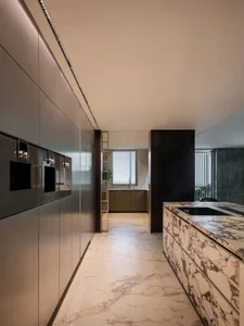 Modern kitchen with marble countertops and floor, sleek design elements.