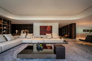 A modern living room featuring a large, comfortable sofa with neutral tones, a sleek coffee table, and a minimalist color pal