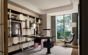 Modern office space featuring wooden elements, glass shelves, and black furniture.