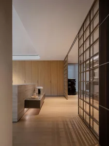 Modern living area with wooden flooring, furniture, and cabinets.