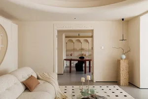 A modern living room with a neutral color palette and a glass coffee table.