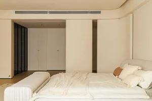 Modern bedroom featuring a minimalist design with neutral materials, including a bed and storage units.