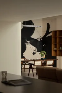 Modern living room featuring wooden furniture, minimalist decor, and a large abstract mural on the wall.