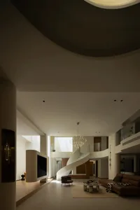 A modern minimalist living room with a spiral staircase, large windows, and a neutral color palette.