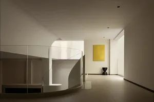 A minimalist interior with a glass staircase.