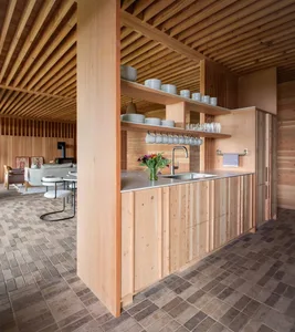 Modern minimalist kitchen with wooden cabinets, stainless steel countertops, and open shelving