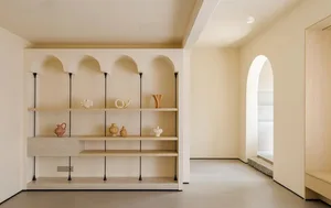 A modern shelf display featuring objects on walnut and concrete shelves with black accents.