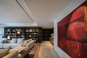 A modern living room with a marble floor and large red artwork on the wall.