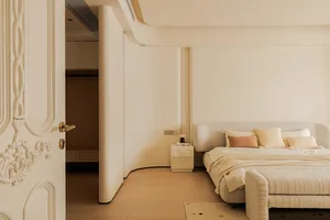 Modern minimalist bedroom in neutral tones with a bed, nightstand, and open closet