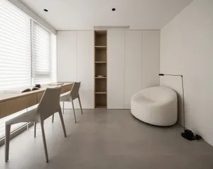 A minimalist home office featuring a white desk, modern white chairs, wooden shelves, and a concrete floor.
