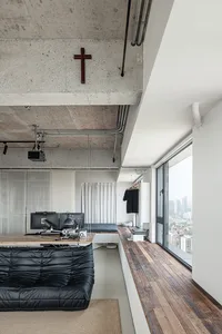 An industrial-style workstation featuring concrete walls and a black couch.