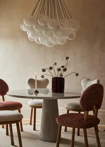 Modern dining room with marble table, wooden chairs, and fabric upholstery