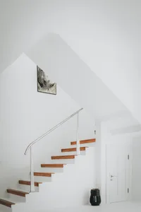 Modern staircase with wooden steps and white walls