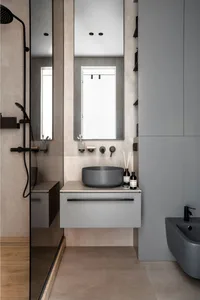 Modern minimalist bathroom with concrete walls and floor, glass shower enclosure, and a floating vanity with a round sink.
