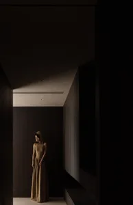 A woman wearing a minimalist dress in a darkly lit, stylish interior setting.