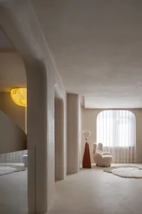 A minimalist residential room featuring soft furnishings and warm lighting.