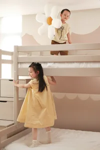 Children playing on a modern bunk bed with white wooden frame, under bright lighting in a play space