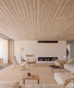 A modern living room with concrete walls, wooden furniture, and fabric accents.