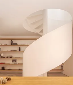 Modern interior space with wooden staircase and concrete walls, featuring a clean, minimalist design.