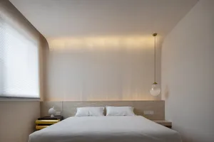 Modern minimalist bedroom featuring a wooden headboard and white blinds.