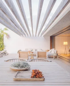 Modern patio with wooden furniture and a skylight ceiling.
